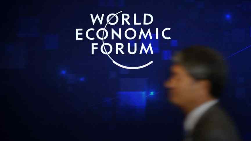 World Economic Forum logo, blurry man in suit, blue background