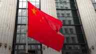 Chinese flag in front of a tall building