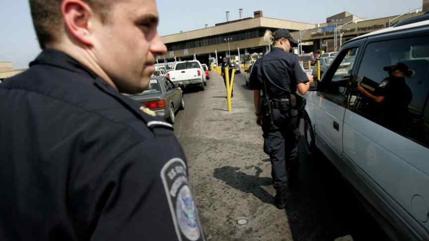 police officers looking at cars before checkpoint