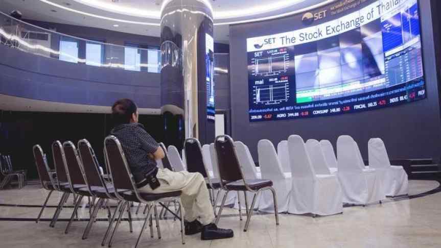 Man sitting in a conference room and watching The Stock Exchange evolution on a big screen