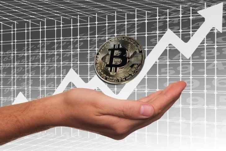 Hands showing a Bitcoin and an ascendant chart