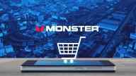 Monster headphone company logo and a shopping cart perpendicular to a mobile phone; cityscape background. 
