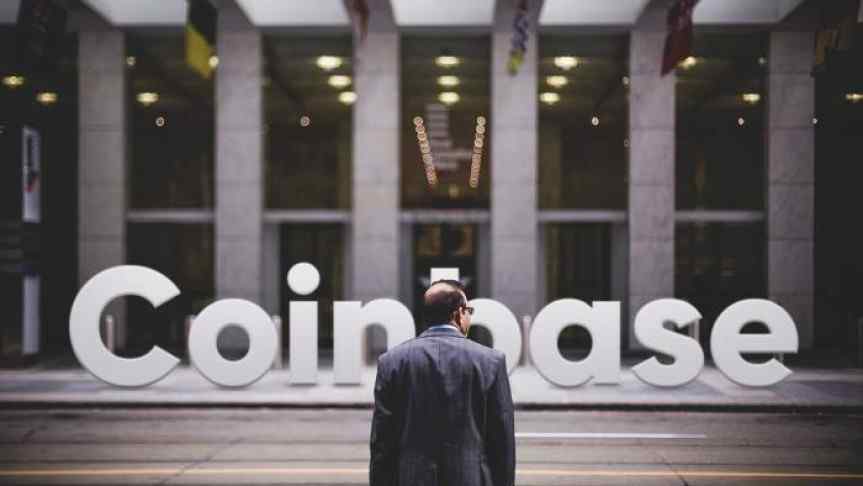 Man in front of a building and the Coinbase logo