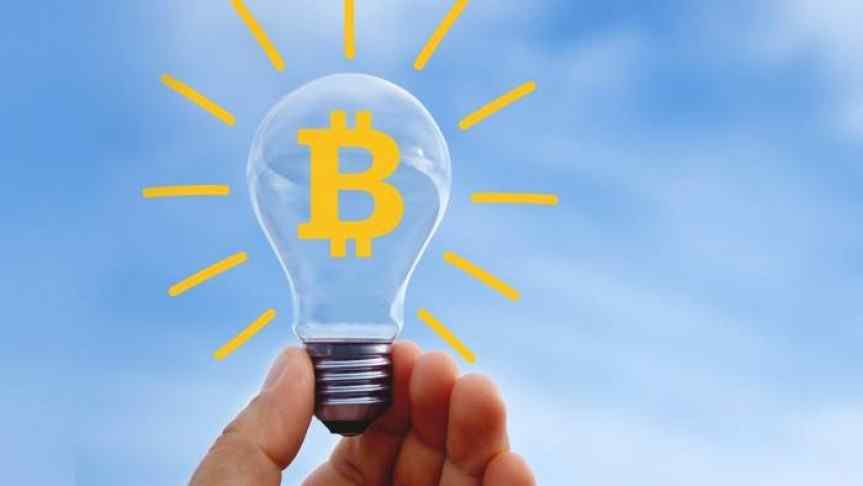 Lightbulb with Bitcoin sign on and drawn yellow sun rays around it; blue sky as background