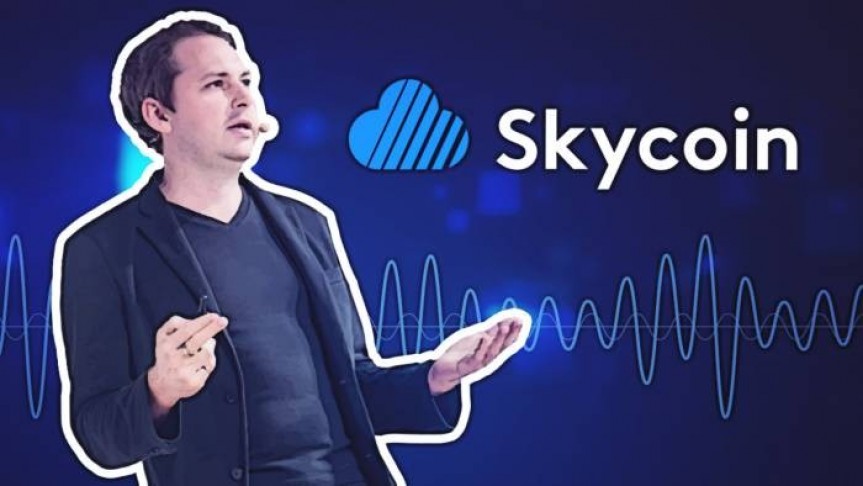 Brandon Synth in suit leaning back on blue background with Skycoin logo and name