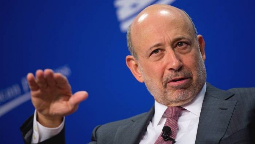 Goldman Sachs in suit, raising hand, blue background