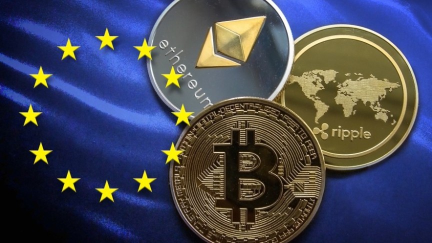 Bitcoin, Ethereum and Ripple gold and silver coins, placed on EU blue flag with yellow stars