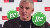 Joe Haslam mid-speech on The Economist background, ITE tokens in green on his right and left