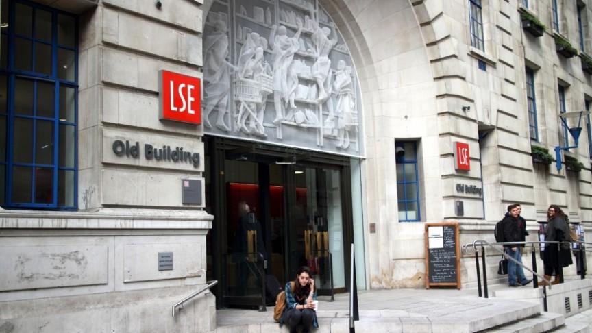 woman sitting on steps in front of LSE building, London