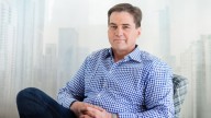Craig Wright in blue checkered shirt, sitting with hands crossed on lap