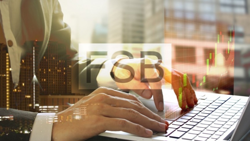 man in suit typing on laptop, translucent FSB logo and graphs in the front