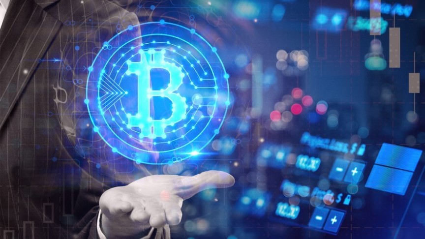 man in striped suit holding out hand, glowing Bitcoin symbol above his hand in blue, in the background computers and graphs