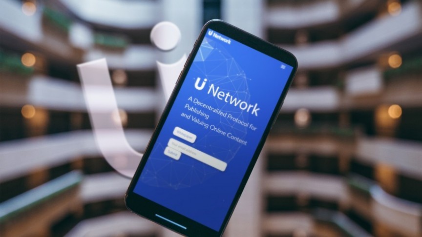 smartphone showing U Network hompage, blurry background