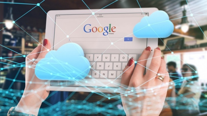 -female hands holding tablet showing Google search engine, blue clouds and blue graphs in the forefront 