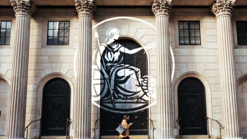 Bank of England, woman walking in front of building with phone, state imprint in the front