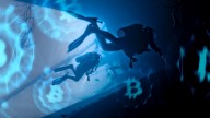 two divers in dark blue waters, Bitcoin logos floating around