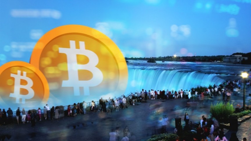 group of people standing around Niagara Falls, big bitcoin logos in orange
