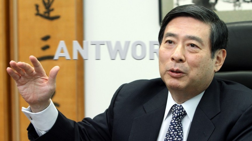 man in suit raising hand, on background of antwork sign written on glass door