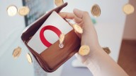 hand holding wallet showing card with Opera logo, gold coins flying around