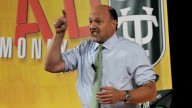 Jim Cramer in bright shirt and green tie, pointing and yelling